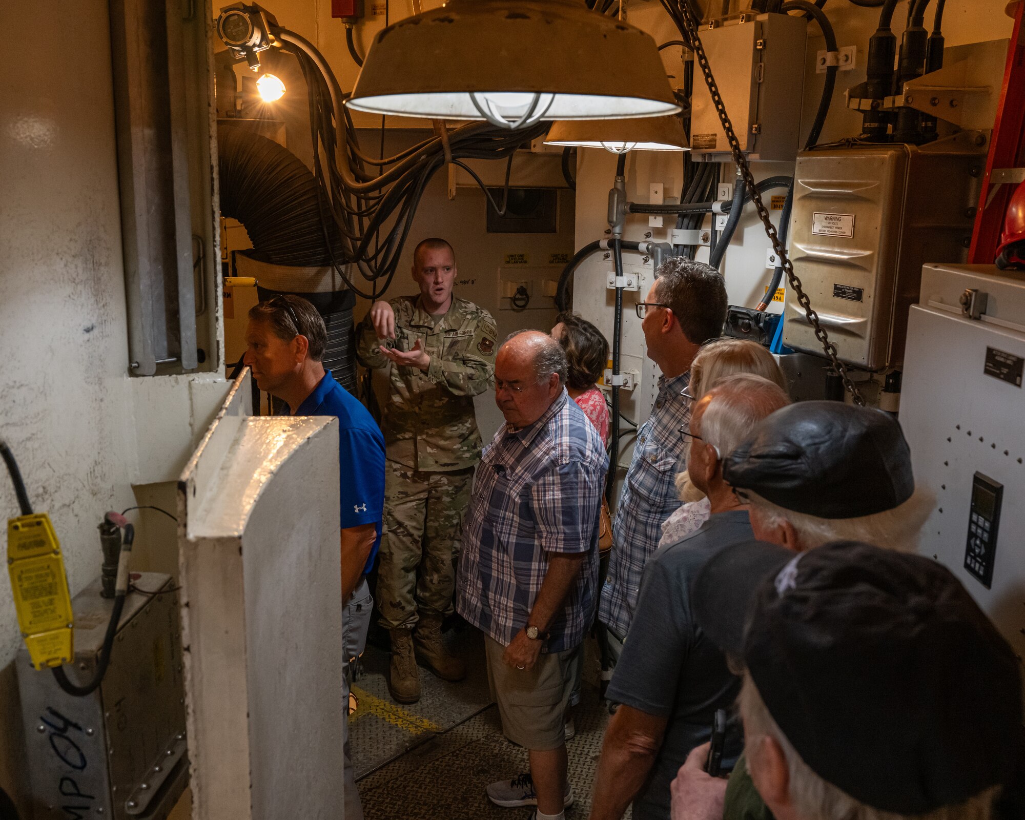 U.S. Air Force Staff Sgt. Seth Mihalak, 373rd Training Squadron operations flight chief, provides a tour of a missile launch training facility to military retirees during Retiree Appreciation Day at Minot Air Force Base, North Dakota, July 12, 2024. The tour allowed the military retirees to see what a modern-day missile launch facility looks like. (U.S. Air Force photo by Senior Airman Kyle Wilson)