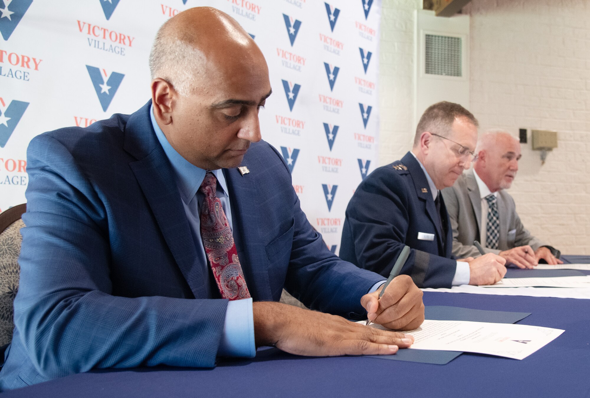 (left to right) Dr. Ravi Chaudhary, Assistant Secretary of the Air Force for Energy, Installations, and Environment; Gen. James Slife, U.S. Air Force deputy chief of staff; and Brooke McLean, retired Air Force Enlisted Village CEO, sign the deed for 80 acres of land purchased from Eglin Air Force Base, Fla., at the Bob Hope Village Commons in Shalimar, Fla., July 12, 2024.