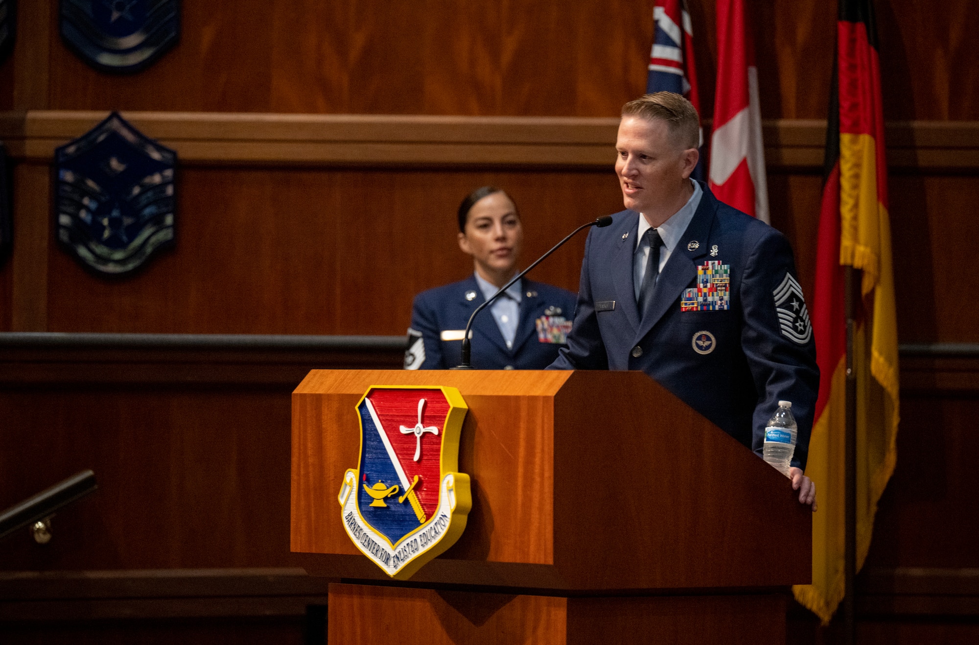 Chief Master Sgt. Joshua Lackey gives his final remarks as the Thomas N. Barnes Center for Enlisted Education command chief during a change of responsibility ceremony on Maxwell Air Force Base, Gunter Annex, Alabama, July 12, 2024. During the ceremony, Col. Damian Schlussel, commander of the Barnes Center, passed the guidon to Chief Master Sgt. Bridget Bruhn signifying the transfer of responsibilities from Lackey to Bruhn. (U.S. Air Force photo/Brian Ferguson)
