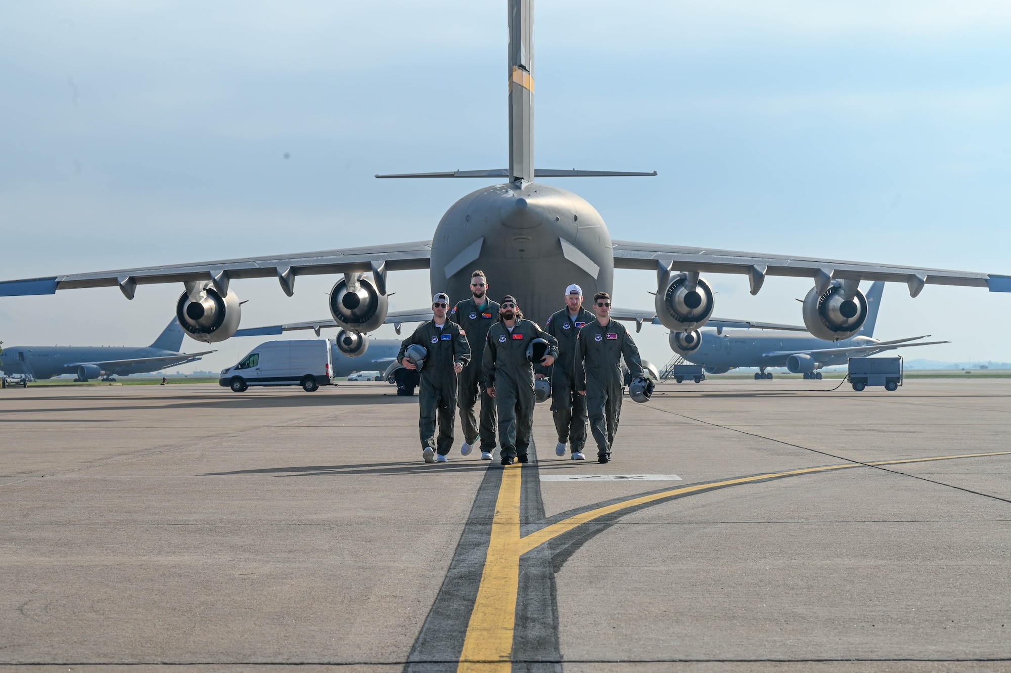 The cast of Dude Perfect walks on the flightline at Altus Air Force Base, Oklahoma, June 12, 2024. This episode highlighted the 97th Air Mobility Wing’s operational proficiency and the rigorous training that goes into forging a mobility Airman. (U.S. Air Force photo by Senior Airman Trenton Jancze)