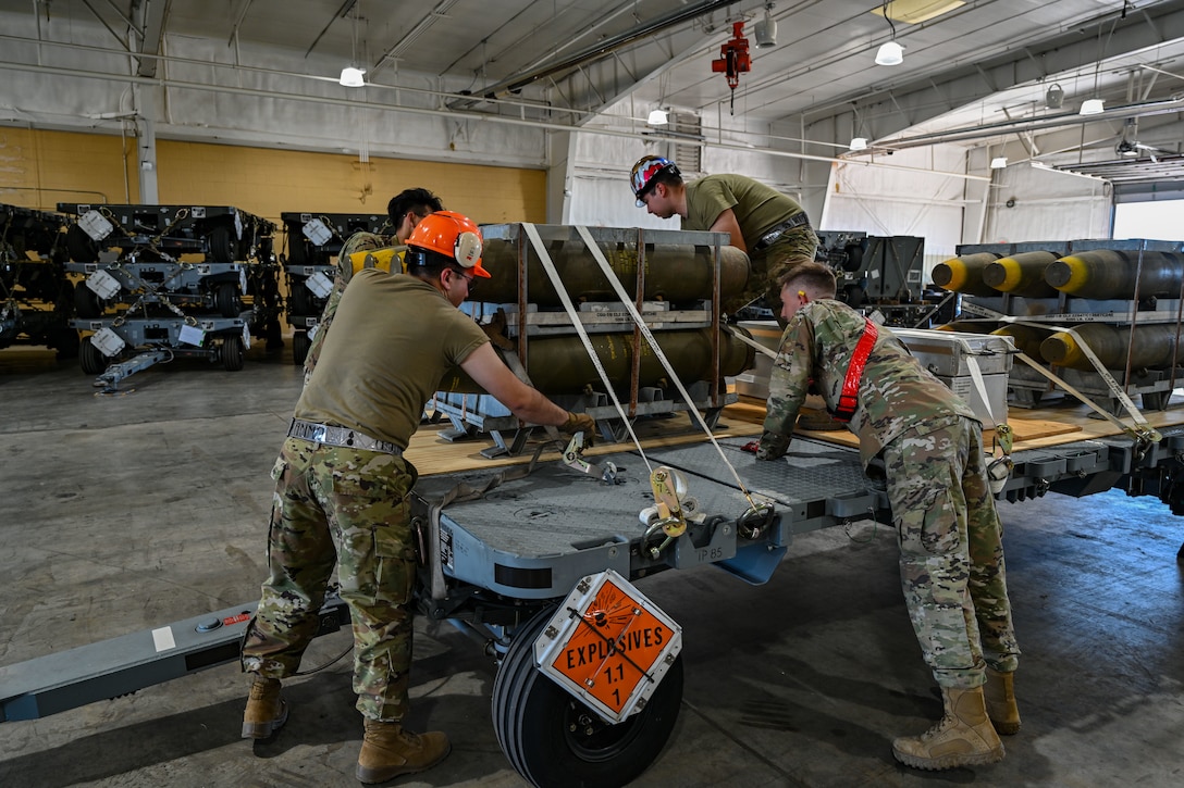 U.S. Air Force Airmen from the 28th Munitions Squadron, strap-down bombs and components during a Combat Ammunition Production Exercise at Ellsworth Air Force Base, S.D., July 9, 2024. The exercise reinforces combat planning and production concepts taught at the Air Force Combat Ammunition Center and gives participating units an opportunity to measure their combat readiness. (U.S. Air Force photo by Staff Sgt. Jake Jacobsen)