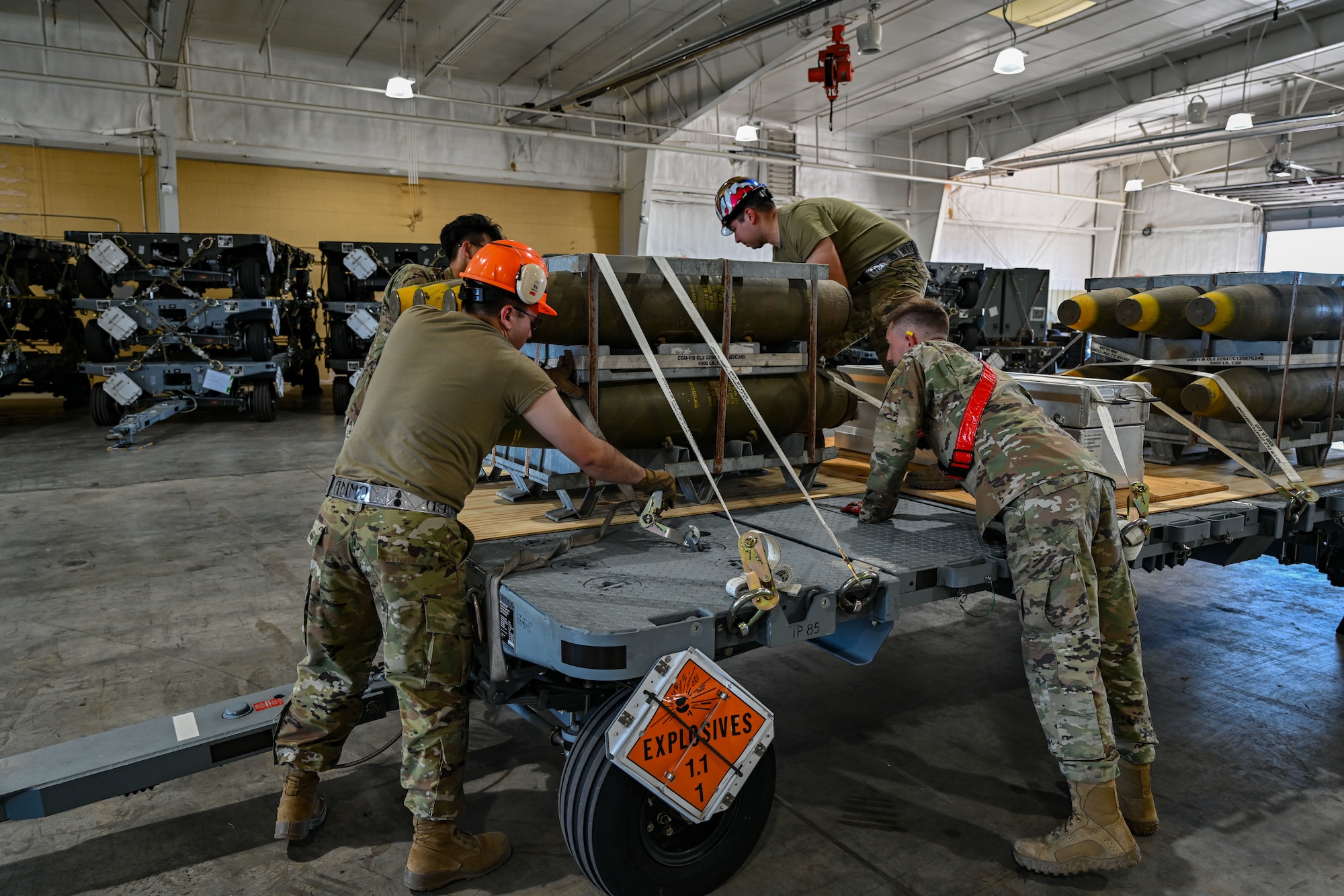 U.S. Air Force Airmen from the 28th Munitions Squadron, strap-down bombs and components during a Combat Ammunition Production Exercise at Ellsworth Air Force Base, S.D., July 9, 2024. The exercise reinforces combat planning and production concepts taught at the Air Force Combat Ammunition Center and gives participating units an opportunity to measure their combat readiness. (U.S. Air Force photo by Staff Sgt. Jake Jacobsen)