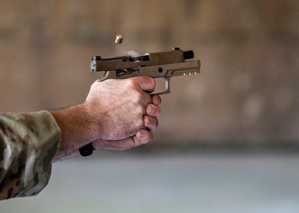 U.S. Air Force Col. Paul Sheets, 23rd Wing commander, fires an M18 pistol at Moody Air Force Base, Georgia, July 12, 2024. Sheets practiced shooting from various positions including prone, standing and kneeling. Battlefield circulations allow the base senior leaders to visit different units to learn about the work the Airmen do and get a true picture of how they operate in their day-to-day duties. (U.S. Air Force photo by Airman 1st Class Leonid Soubbotine)