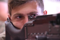 U.S. Air National Guard Senior Airman Kolby Gries, 185th Air Refueling Wing Security Forces, looks through the sights of a M240B machine gun at the Alpena Combat Readiness Training Center near Alpena, Michigan, July 11, 2024. Security Forces Airmen of the Iowa Air National Guard were training on air base ground defense, urban tactical operations, weapons and equipment, and security forces procedures.