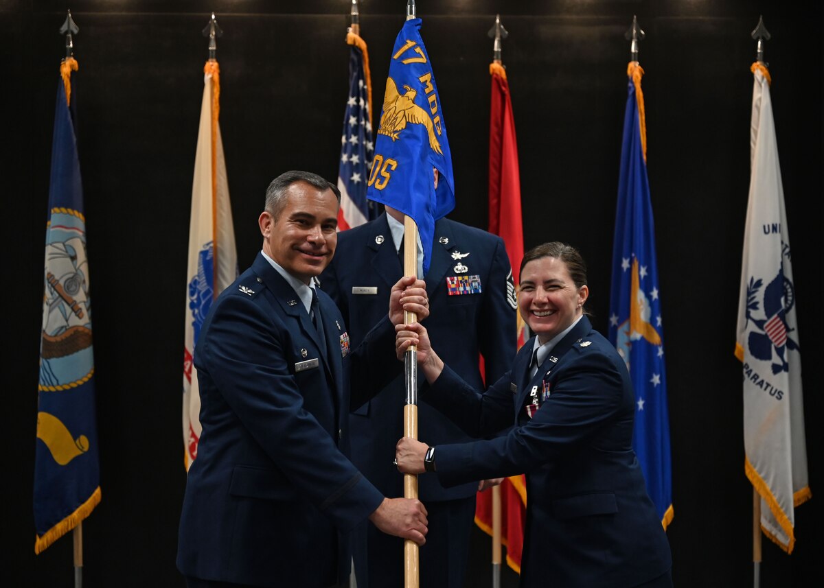 U.S. Air Force Col. Ian Rybczynski, 17th Medical Group commander, takes the guidon from Lt. Col. Jennifer Johnson, outgoing 17th Healthcare Operations Squadron commander, during the change of command ceremony at the Powell Event Center, Goodfellow Air Force Base, Texas, July 12, 2024. Passing the guidon represents the transfer of leadership responsibilities to the next commander. (U.S. Air Force photo by Senior Airman Zach Heimbuch)