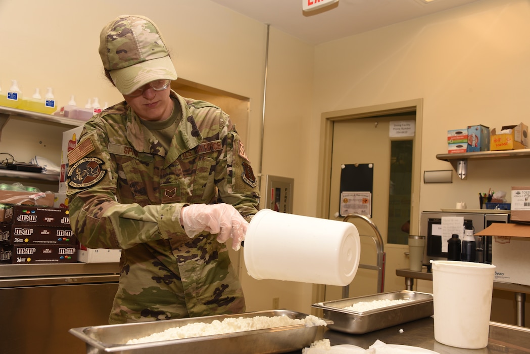 Staff Sgt. Zoe Spink, 185th Air Refueling Wing Services, puts cottage cheese in a long pan