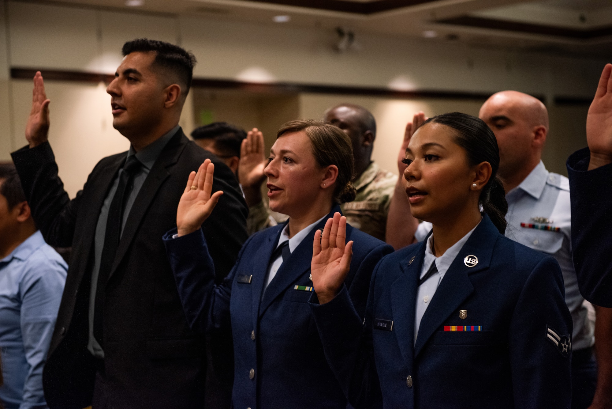 Candidates raising their right hand and recite the oath of allegiance.