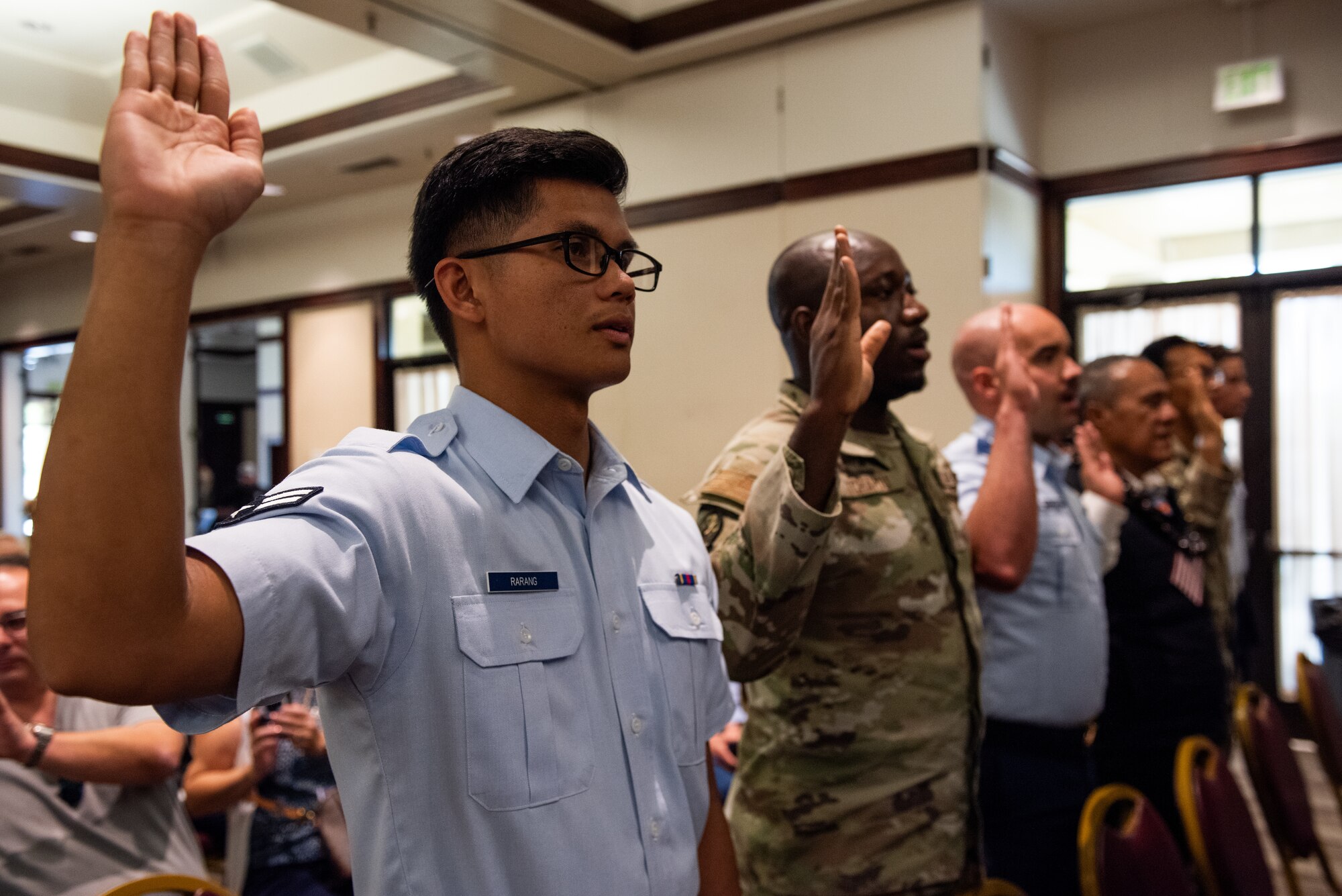 Candidates raising their right hand to recite the oath.