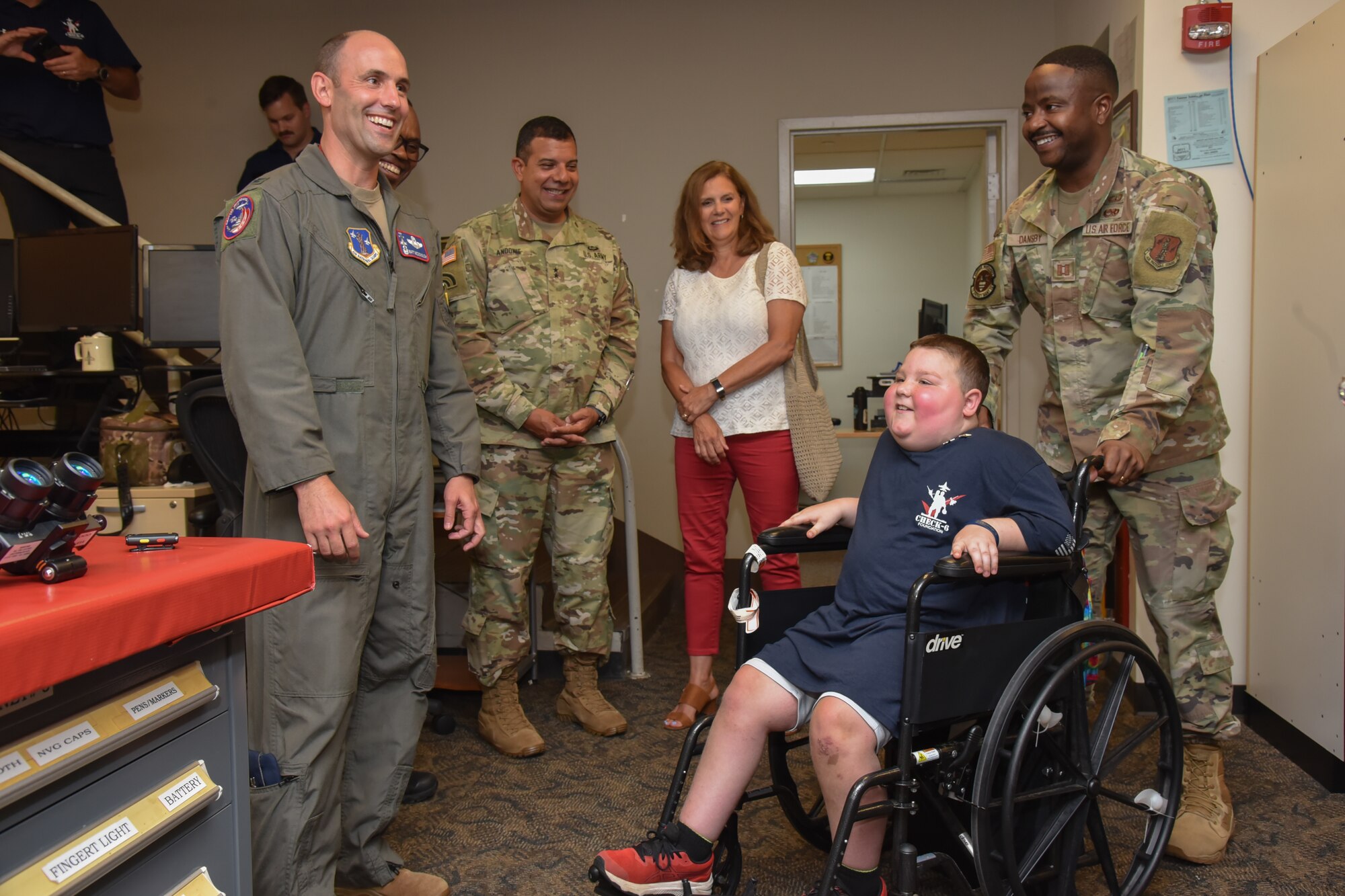 Child in wheelchair with Air Force leaders.