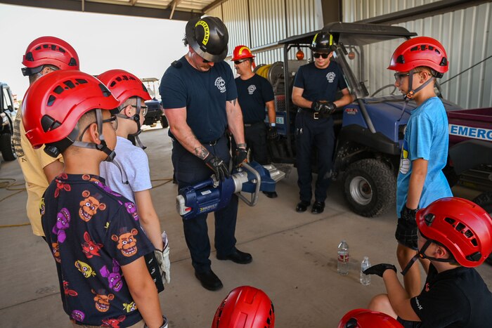 Lt. Gavin Maltias, Goodfellow Fire Department B-Shift firefighter, demonstrates use of the Jaws of Life to students during the second day of the 2024 Junior Firefighter Camp at the Goodfellow Fire Department, Goodfellow Air Force Base, Texas, July 9, 2024. The rescue tool demonstration was a challenge where students picked up and carried an open bottle of water without spilling the water. (U.S. Air Force photo by Airman 1st Class Evelyn J. D’Errico)