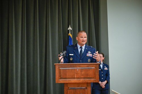 A military service member speaks on stage.