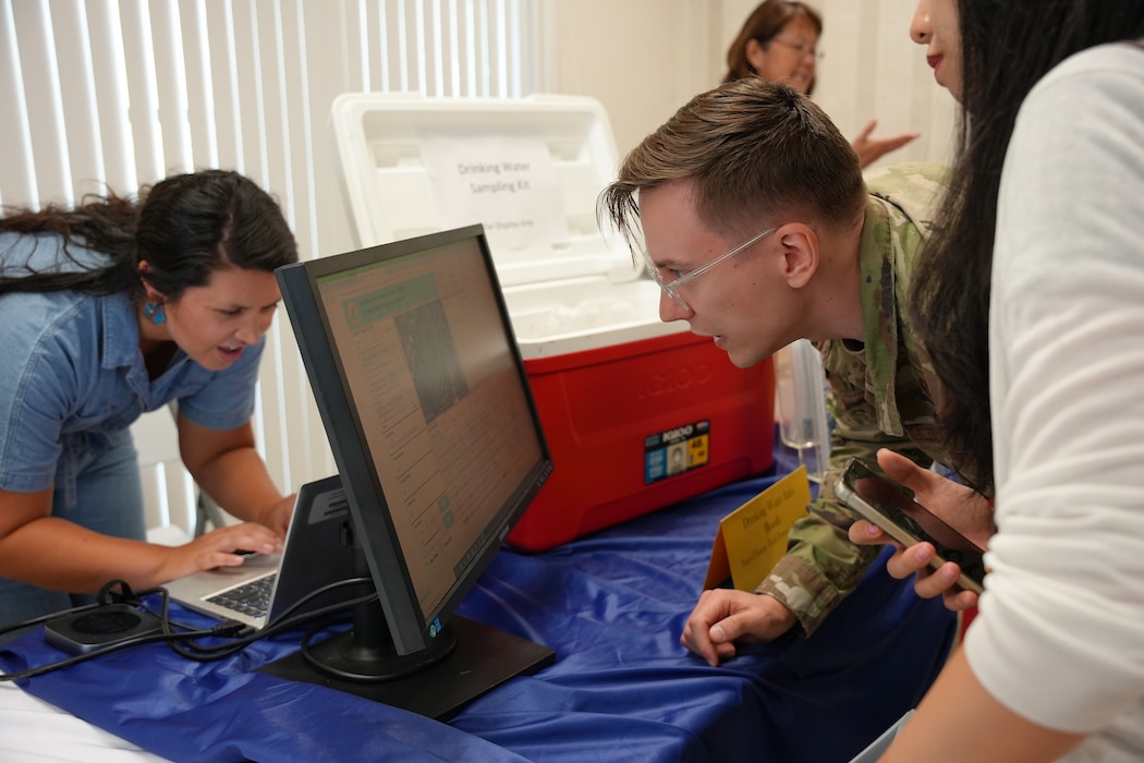 JOINT BASE PEARL HARBOR-HICKAM, Hawaii (July 9, 2024) A community liaison officer for Navy Closure Task Force-Red Hill (NCTF-RH) shows a resident water testing results and shares information about the Extended Drinking Water Monitoring (EDWM) plan and Water Quality Action Team (WQAT) while manning a drinking water information booth at the Hickam Chapel on Joint Base Pearl Harbor-Hickam, Hawaii, July 9, 2024. The Navy voluntarily instituted the EDWM and WQAT programs in April 2024 following the end of the two-year drinking water Long-Term Monitoring program. The programs are designed to provide resources and enhanced water sampling and testing for residents on the JBPHH drinking water system. (U.S. Navy photo by Mass Communication Specialist Seaman Krystal Diaz)