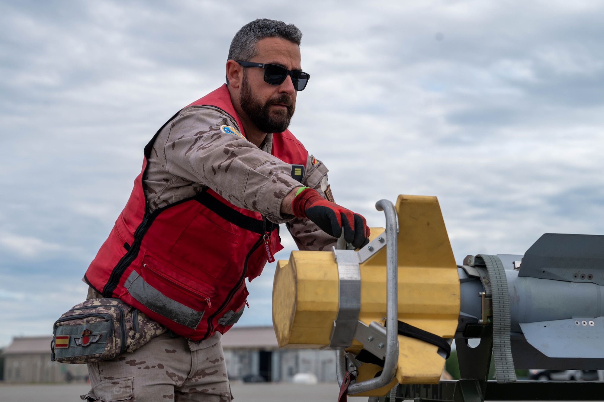 A maintainer from the Spanish Air Force loads simulated weaponry on a Eurofighter Typhoon.