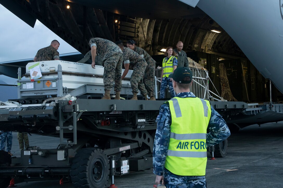 U.S. Marines with Marine Aviation Logistics Squadron 24, Marine Aircraft Group 24, 1st Marine Aircraft Wing and an Australian Aviator with 11 Squadron, Royal Australian Air Force unload gear together in support of Exercise Rim of the Pacific (RIMPAC) 2024, Marine Corps Air Station Kaneohe Bay, Hawaii, July 2, 2024. Twenty nine nations, 40 surface ships, three submarines, 14 national land forces, more than 150 aircraft and 25,000 personnel are participating in Exercise Rim of the Pacific (RIMPAC) in and around the Hawaiian Islands, June 27 to Aug. 1. The world's largest international maritime exercise, RIMPAC provides a unique training opportunity while fostering and sustaining cooperative relationships among participants critical to ensuring the safety of sea lanes and security on the world's oceans. RIMPAC 2024 is the 29th exercise in the series that began in 1971. (Marine Corps photo by Cpl. Joseph Abreu)
