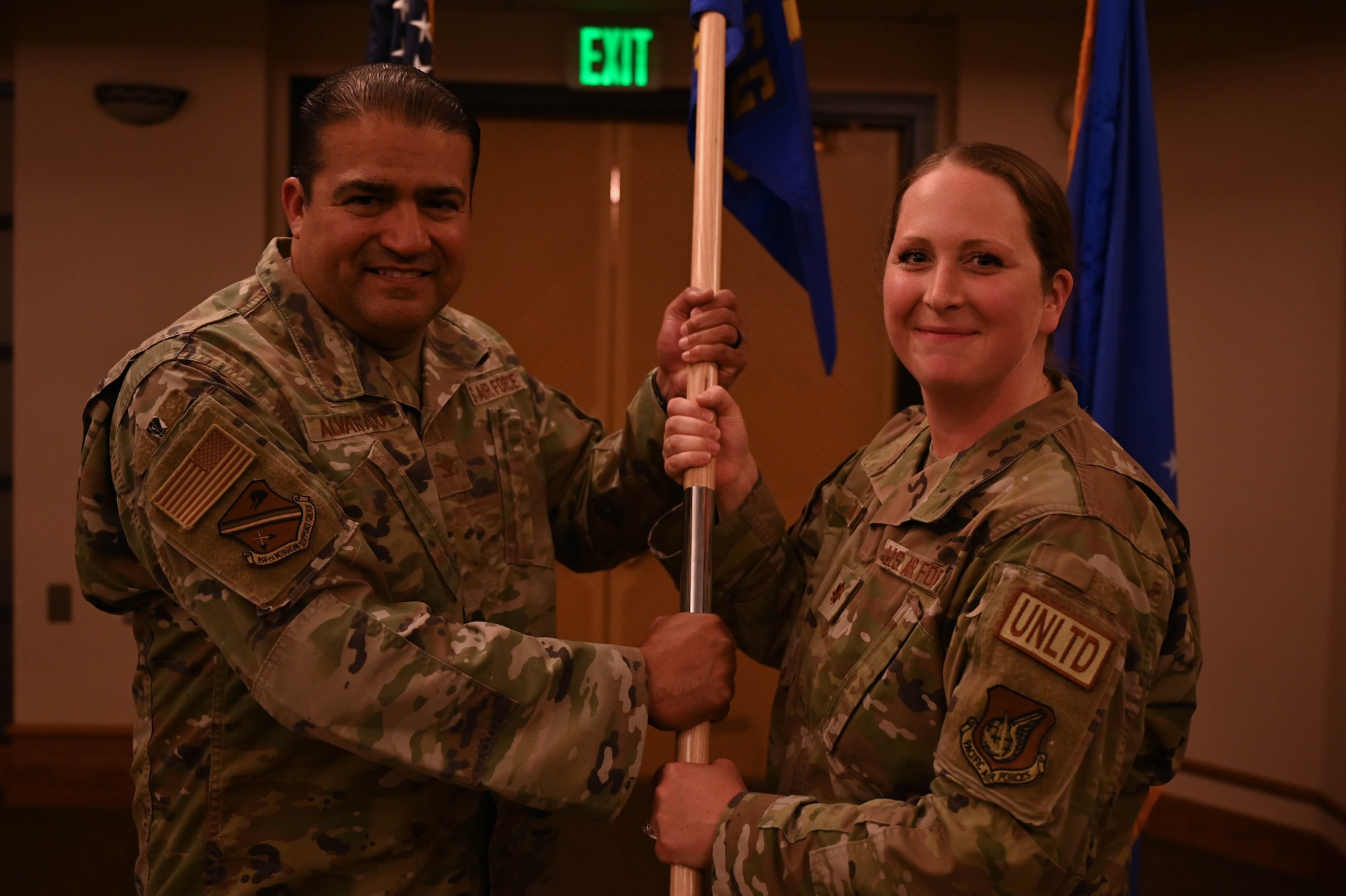 Maj. Meredith Adams, hands the flag guidan to Col. Antonio Alvarado, 354th Maintenance Group commander, during the squadron’s change of command ceremony.