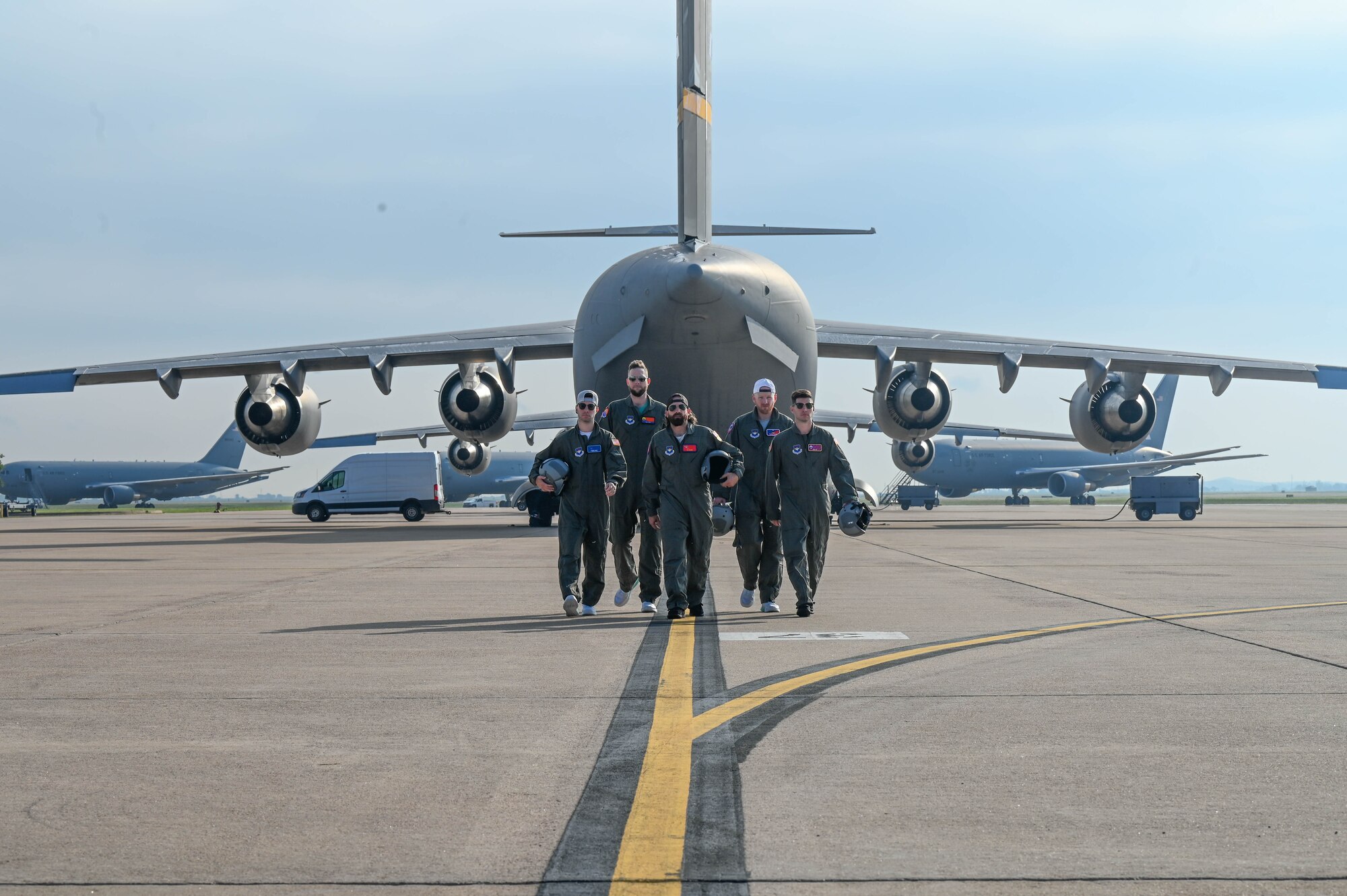 The cast of Dude Perfect walks on the flightline at Altus Air Force Base, Oklahoma, June 12, 2024. This episode highlighted the 97th Air Mobility Wing’s operational proficiency and the rigorous training that goes into forging a mobility Airman. (U.S. Air Force photo by Senior Airman Trenton Jancze)