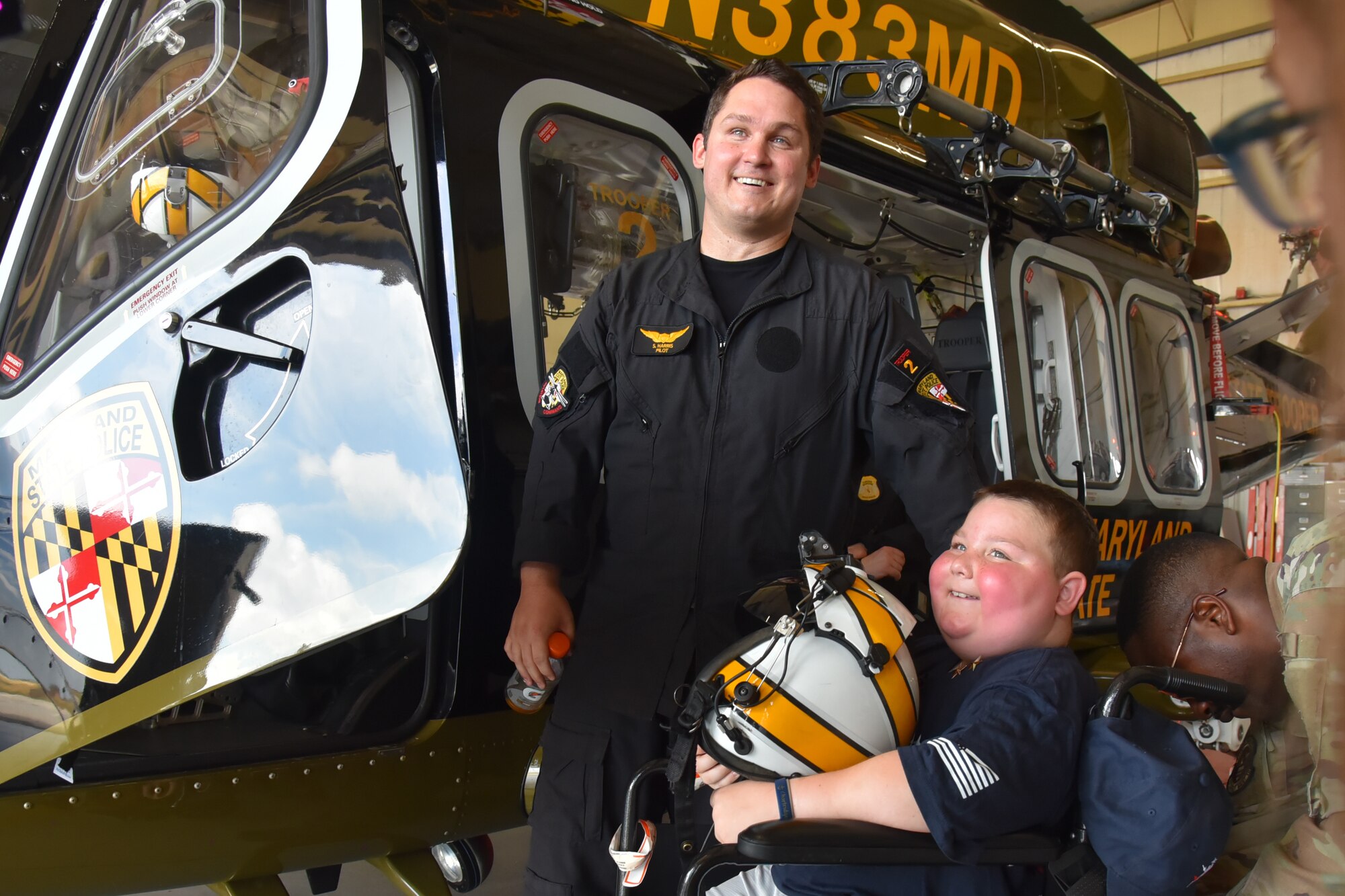 Pilot and child in front of helicopter.