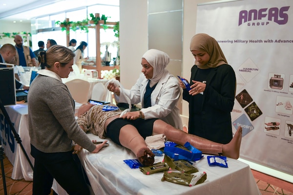 Participants from the Multinational Combat Casualty Care Engagement conference, exchange techniques and best practices during a lifesaving medical treatment training, July 1.