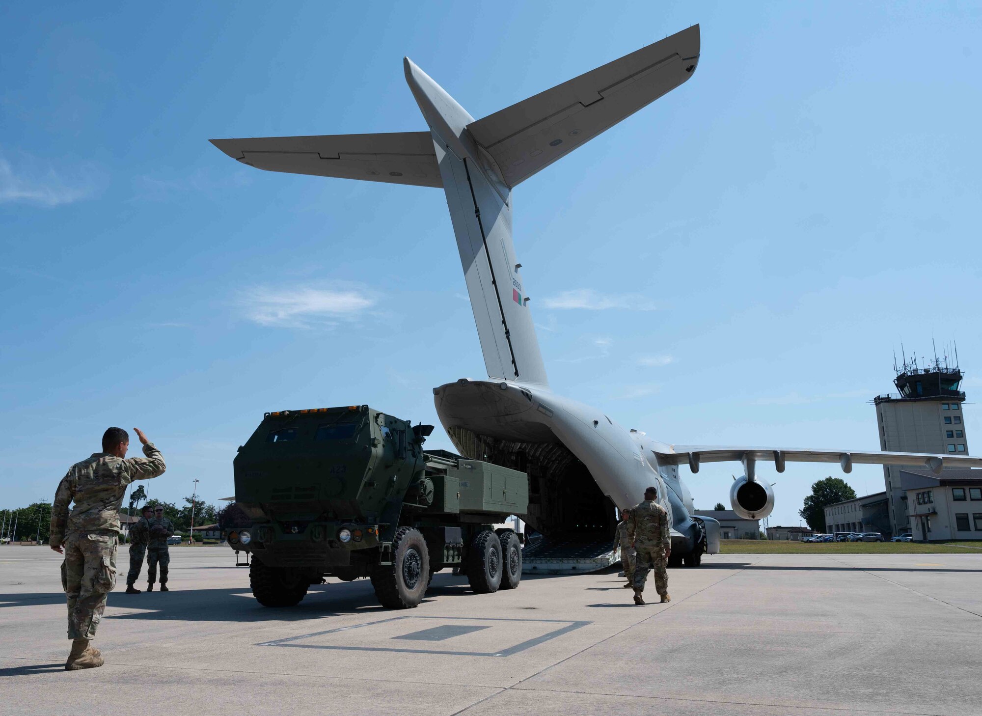 U.S. and Portuguese service members guide an M142 High Mobility Rocket System out of a Portuguese KC-390 Millennium aircraft during cold load training