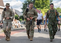 U.S. Army Pfc. Damien Boccardi and Sgt. 1st Class Corrie Heffner, both assigned to V Corps, walk alongside a member of the Royal Dutch Army on the route of the Nijmegen March in Nijmegen, Netherlands, July 16, 2024. The endurance required to complete the march represents the endurance that Soldiers strive for in their bond with international allies and partners. (U.S. Army photo by Sgt. Omar Joseph, Sr.)