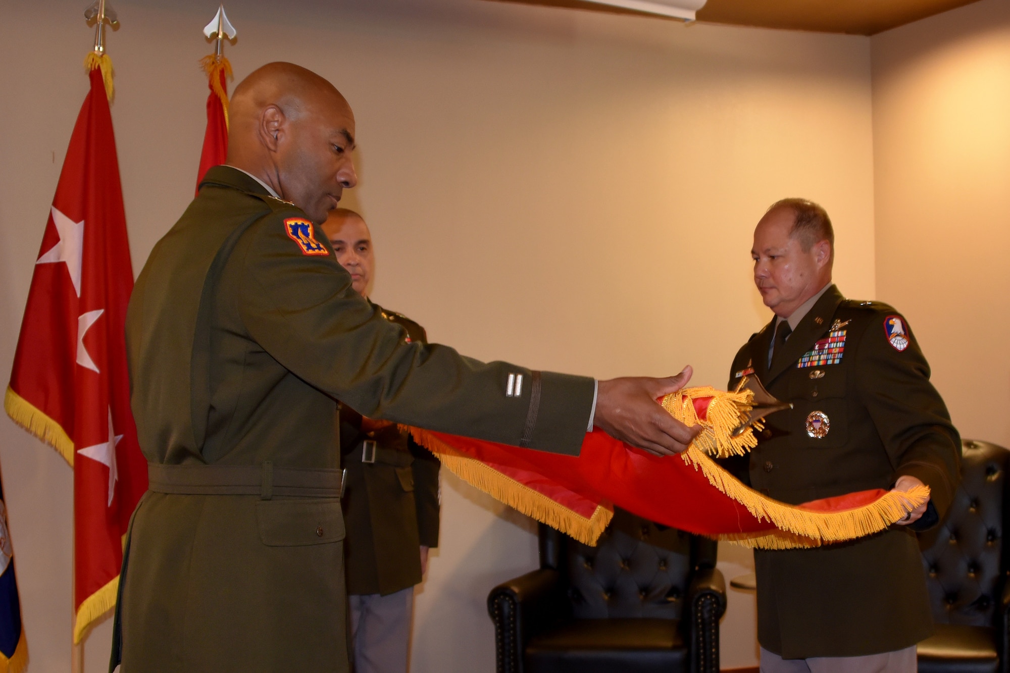 Lt. Gen. Sean A. Gainey, commanding general, U.S. Space and Missile Defense Command, and Brig. Gen. John L. Dawber, SMDC deputy commanding general for operations, unfurl the one-star flag at Dawber's promotion ceremony at Peterson Space Force Base, Colorado, July 12, 2024. Command Sgt. Maj. John W. Foley, command sergeant major for SMDC, presented the flag. (U.S. Army photo by Dottie White)