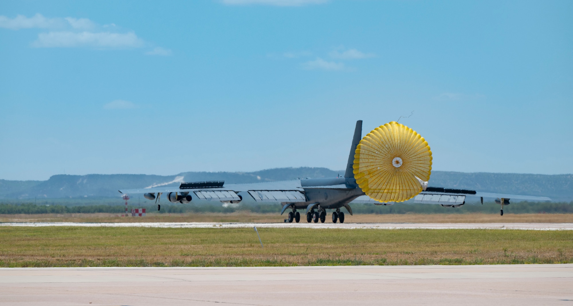 A B-52 Stratofortress assigned to the 23rd Bomb Squadron at Minot Air Force Base, North Dakota, deploys a drag chute at Dyess Air Force Base, Texas, July 15, 2024. The aircraft are operating out of Dyess while upgrades are being made to the Minot runway, showcasing their ability to operate at forward locations. (U.S. Air Force photo by Airman 1st Class Emma Anderson)