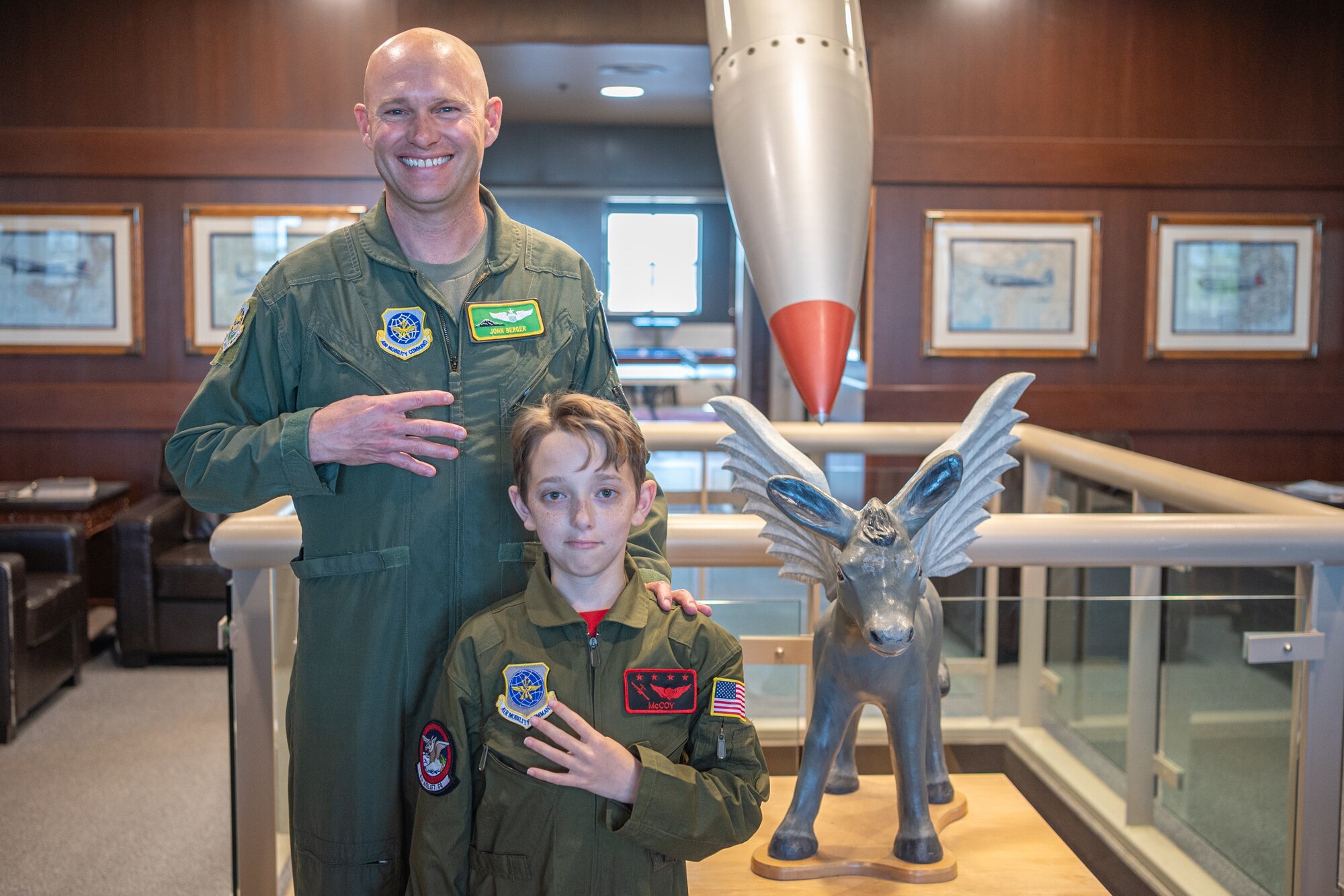 U.S. Air Force Col. John Berger, the 62d Airlift Wing deputy commander, and McCoy Cannon, Team McChord’s newest 12-year-old “Pilot for a Day” participant, stand together in the 4th Airlift Squadron building at Joint Base Lewis-McChord, Washington, July 11, 2024.