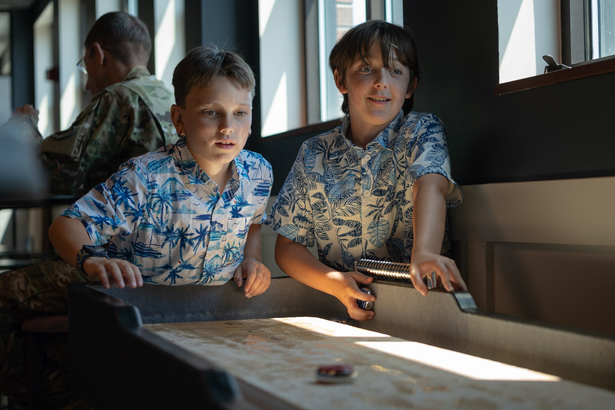Mason Cannon, left, and Ryder Cannon play shuffleboard in the 4th Airlift Squadron’s heritage room at Joint Base Lewis-McChord, Washington, July 11, 2024.