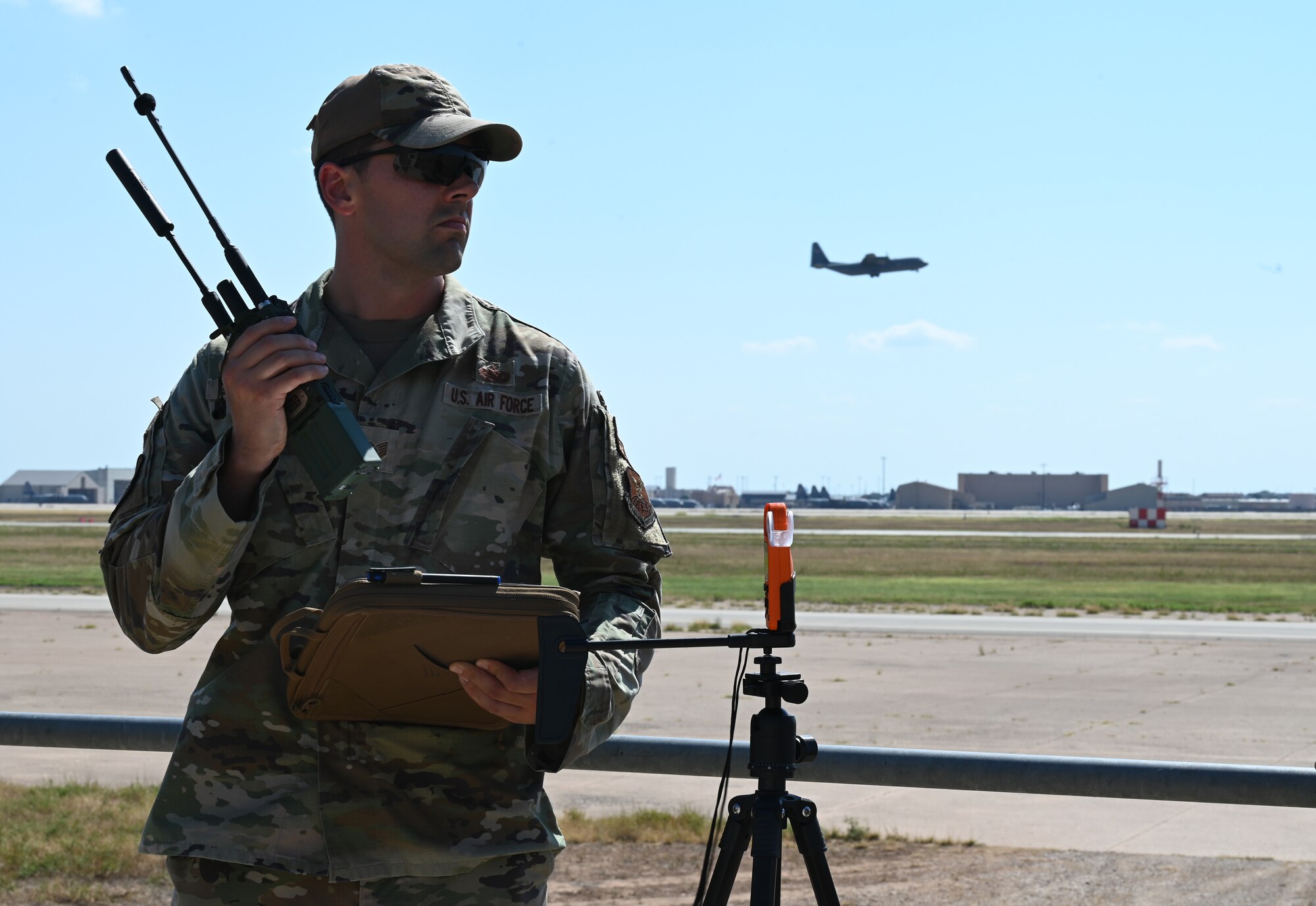 Tech. Sgt. Nicholas Goldsmith, 7th Operations Support Squadron radar, airfield and weather systems NCO in charge, communicates with an incoming C-130J Super Hercules during the Landing Zone Safety Officer Exercise at Dyess Air Force Base, Texas, July 12, 2024. Seven air traffic control Airmen spent two weeks honing skills used in deployed and underdeveloped locations bringing Agile Combat Employment to the forefront of the Air Force airfield operations career fields. (U.S. Air Force photo by Staff Sgt. Holly Cook)