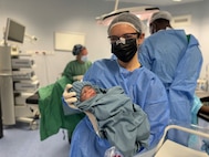 Senior Airman Megan Haley, a medic with the New Hampshire Air National Guard, holds a newborn baby after assisting with the delivery during a multi-national medical exercise in Kédougou, Senegal, led by the Vermont National Guard on June 6, 2024. The exercise included Airmen and Soldiers with the Vermont and New Hampshire National Guard, medical teams with the Austrian and Senegalese armed forces who all worked alongside hospital teams located locations throughout Senegal.