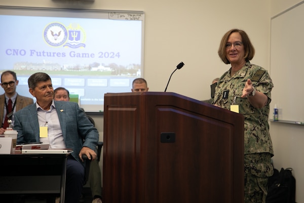 Chief of Naval Operations Adm. Lisa Franchetti delivers remarks at the CNO Futures Game at Naval Station Newport, Rhode Island, July 16, 2024. The Navy uses events like the CNO Futures Game as part of an ongoing series of Joint and Navy-sponsored events to shape and inform naval strategy, analysis, operational concepts, and warfighting requirements. This image has been altered by obscuring badges for security purposes. (U.S. Navy photo by Senior Chief Mass Communication Specialist Elliott Fabrizio/released)