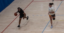 U.S. Air Force Airman Kyasia Overstreet, 5th Logistics Readiness Squadron inbound technician and Lady Bomber (left), plays basketball at Minot Air Force Base, North Dakota, July 10, 2024. Basketball is important to Overstreet because it provides an active outlet for stress. (U.S. Air Force photo by Airman 1st Class Alyssa Bankston)