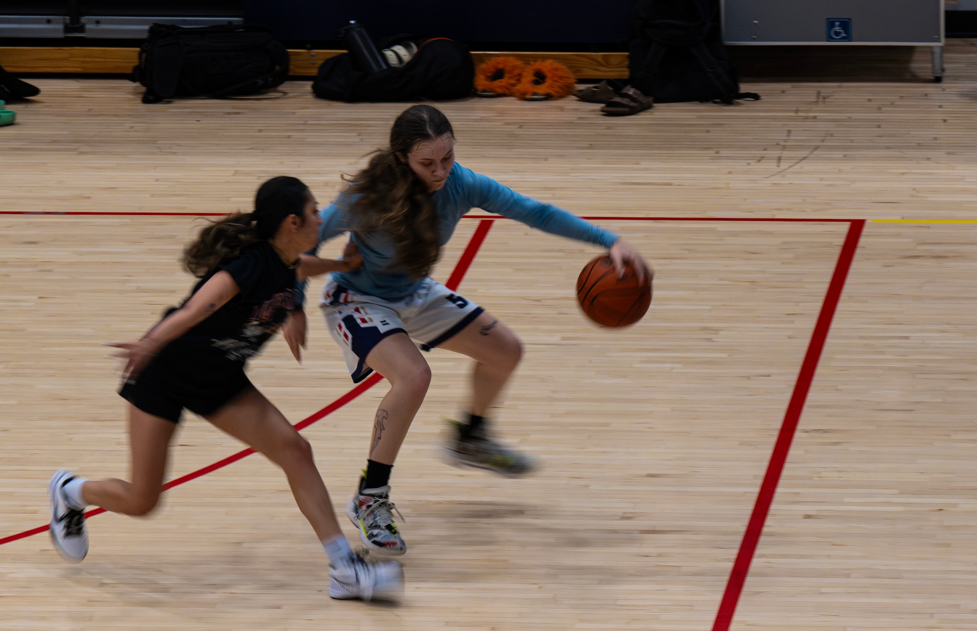 U.S. Air Force Airman 1st Class Emily Leavitt, 5th Logistics Readiness Squadron household goods technician and Lady Bomber, executes a crossover during a drill for a Minot Air Force Base (AFB) Lady Bombers basketball practice session at Minot AFB, North Dakota, July 10, 2024. Leavitt has been playing basketball for 14 years. (U.S. Air Force photo by Airman 1st Class Alyssa Bankston)