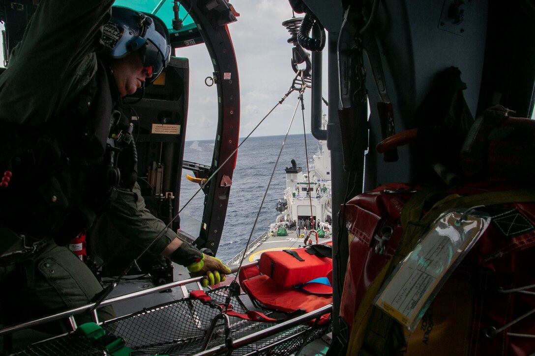 U.S. Coast Guard Petty Officer 1st Class Chris Parrinello, an avionics electrical technician assigned to the U.S. Coast Guard Cutter Waesche (WMSL-751), prepares to lower a litter from a U.S. Coast Guard MH-65E helicopter for a hoist demonstration aboard the Philippine Coast Guard vessel Melchora Aquino (MRRV-9702) during a bilateral U.S.-Philippine search and rescue exercise in the South China Sea, July 16, 2024. The bilateral exercise was an opportunity to strengthen relations by working together and exchanging operating procedures and practices.  Waesche is the second U.S. Coast Guard National Security Cutter deployed to the Indo-Pacific in 2024. Coast Guard cutters routinely deploy to the region to engage with partner nations to ensure a free and open Indo-Pacific.  (U.S. Coast Guard courtesy photo)