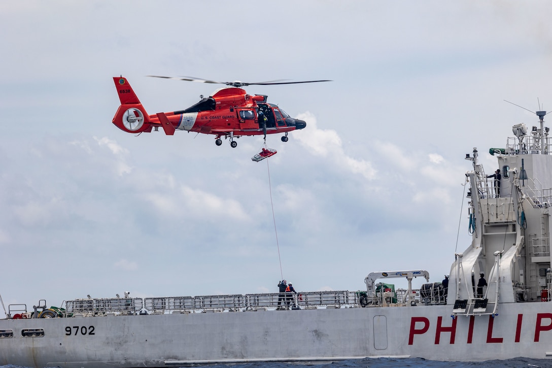 U.S. Coast Guardsmen,  assigned to the U.S. Coast Guard Cutter Waesche (WMSL-751), retrieve a litter onto a U.S. Coast Guard MH-65E helicopter from the flight deck of the Philippine Coast Guard Vessel Melchora Aquino (MRRV-9702) during a bilateral U.S.-Philippine search and rescue exercise in the  South China Sea, July 16, 2024. The bilateral exercise was an opportunity to strengthen relations by working together and exchanging operating procedures and practices. Waesche is the second U.S. Coast Guard National Security Cutter deployed to the Indo-Pacific in 2024. Coast Guard cutters routinely deploy to the region to engage with partner nations to ensure a free and open Indo-Pacific.  (U.S. Marine Corps photo by Cpl. Elijah Murphy)