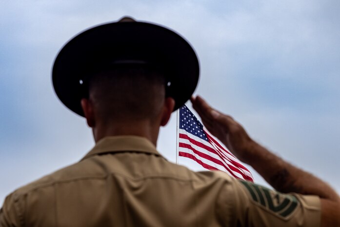 U.S. Marine Corps Gunnery Sgt. Donald Vilchek, regimental drill master for Recruit Training Regiment, salutes the colors during the national anthem at a graduation ceremony for India Company, 3rd Recruit Training Battalion, Marine Corps Recruit Depot San Diego, California, July 12, 2024. Graduation took place at the completion of the 13-week transformation, which included training for drill, marksmanship, basic combat skills, and Marine Corps customs and traditions. (U.S. Marine Corps photo by Cpl. Alexander O. Devereux)