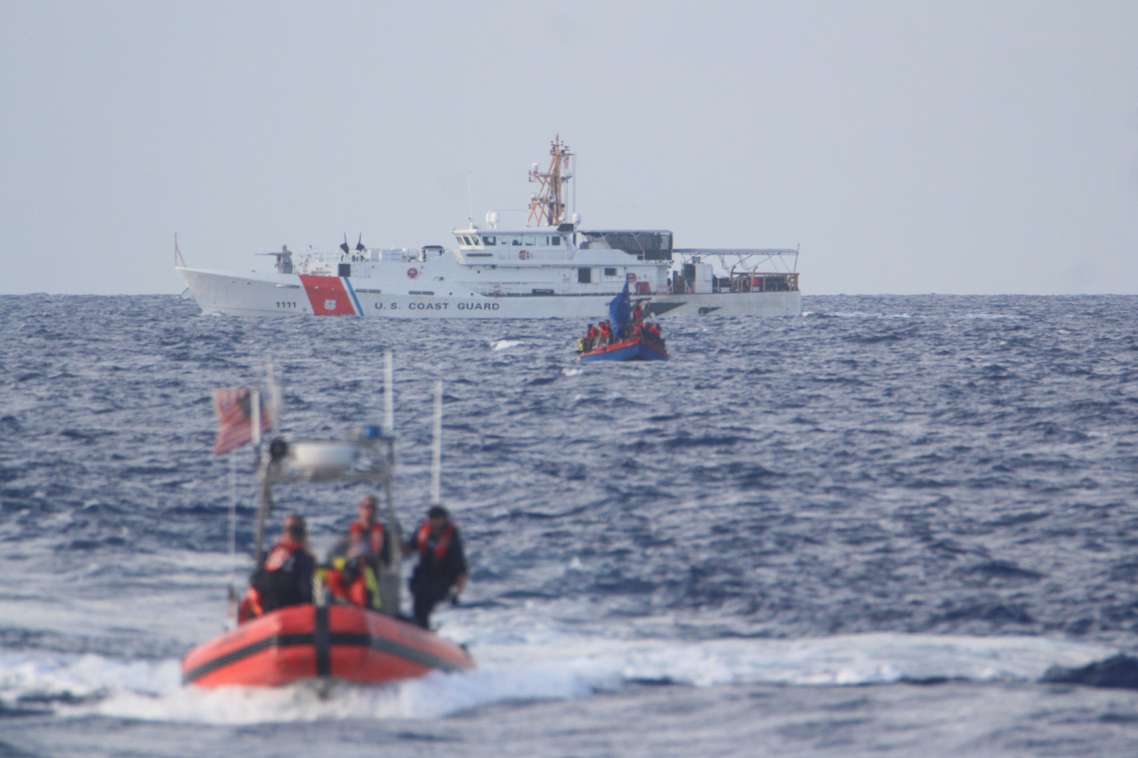 Coast Guard Cutter Valiant’s (WMEC 621) small boat crew transfers Haitians from an overloaded migrant vessel, June 6, 2024, back to Valiant with support from Coast Guard Cutter William Trump (WPC-1111), background, while at sea in the Windward Passage. Valiant and its crew conducted a 49-day maritime safety and security patrol in the Florida Straits and Windward Passage. (U.S. Coast Guard photo)