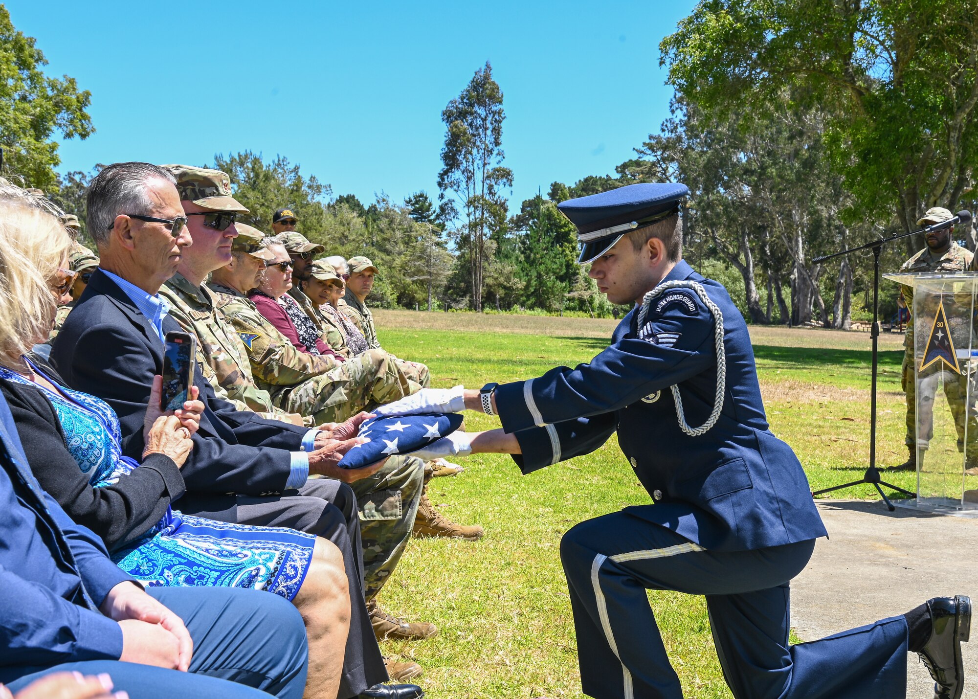 A Vandenberg Honor Guard, presents Victor Cocheo, brother of late U.S. Air Force 4392d Civil Engineer Squadron former commander, a folded flag during the Cocheo Park Commemoration Ceremony at Vandenberg Space Force Base.