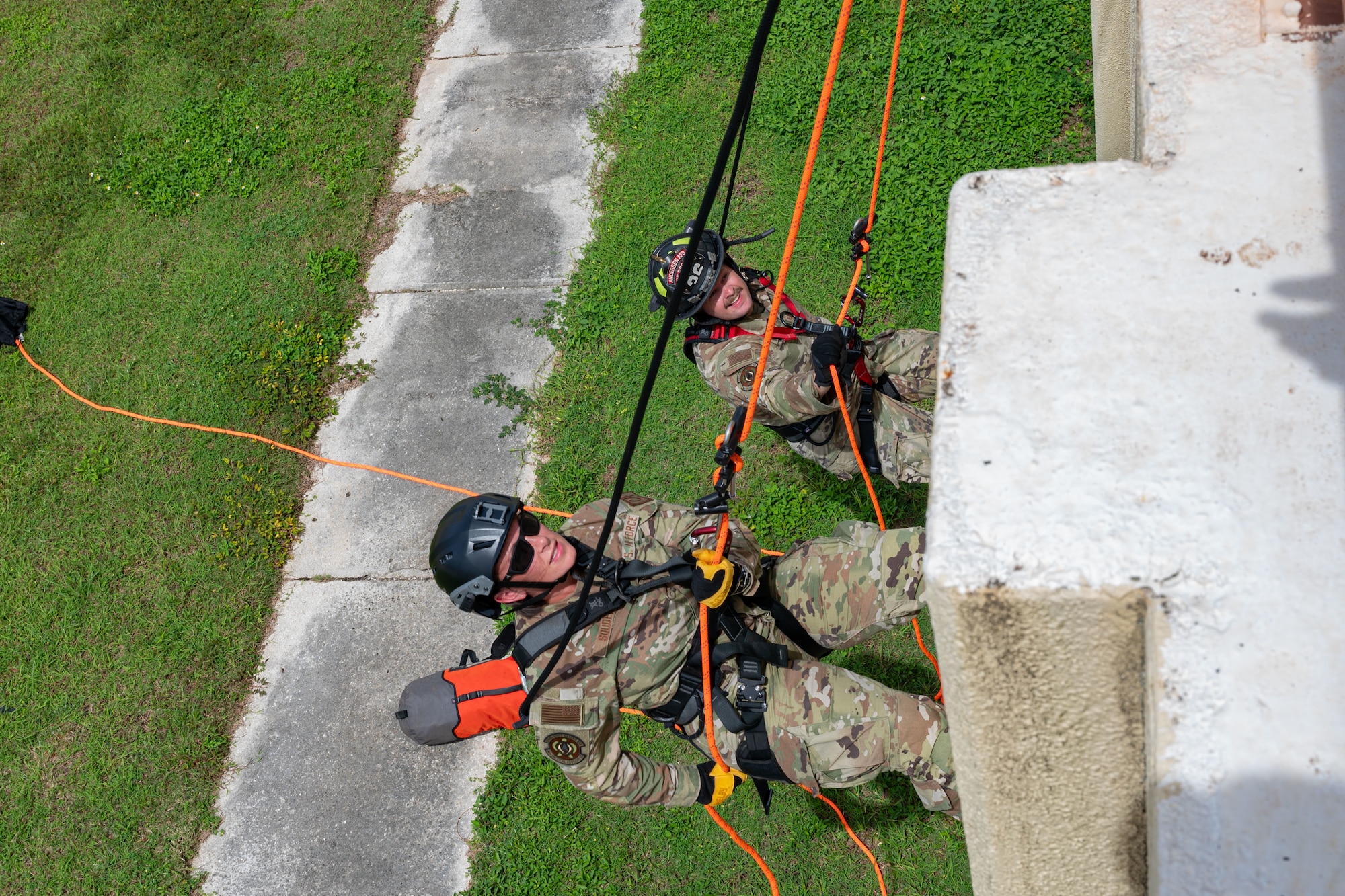 U.S. Air Force Tech. Sgt. Brittany Souder, left, 36th Tactical Advisory Squadron independent duty medical technician, and Tech. Sgt. Kyle Yeomans, 36 TAS survival, evasion, resistance and escape specialist, rappel during rescue technician training at Andersen Air Force Base, Guam, July 16, 2024.