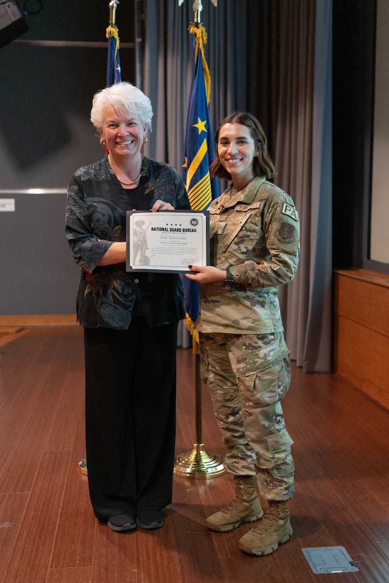 U.S. Air Force Airman 1st Class Victoria Jewett, a public affairs specialist with the 156th Wing, Puerto Rico Air National Guard, receives a first-place certificate in the Multimedia Product category of the Air National Guard Media Awards Competition from Tracey O' Grady-Walsh, director of Public Affairs for the National Guard Bureau, during the National Guard's annual Public Affairs Training Workshop Conference at the Mark Center, Alexandria, Virginia, July 11, 2024. The PATW is a three-day training event that is attended primarily by speakers and public affairs professionals providing expansive talks from strategic leaders and collaborative networking to bridge the PA community across the 54 U.S. states and territories. (U.S. Air National Guard photo by Master Sgt. Rafael D. Rosa)