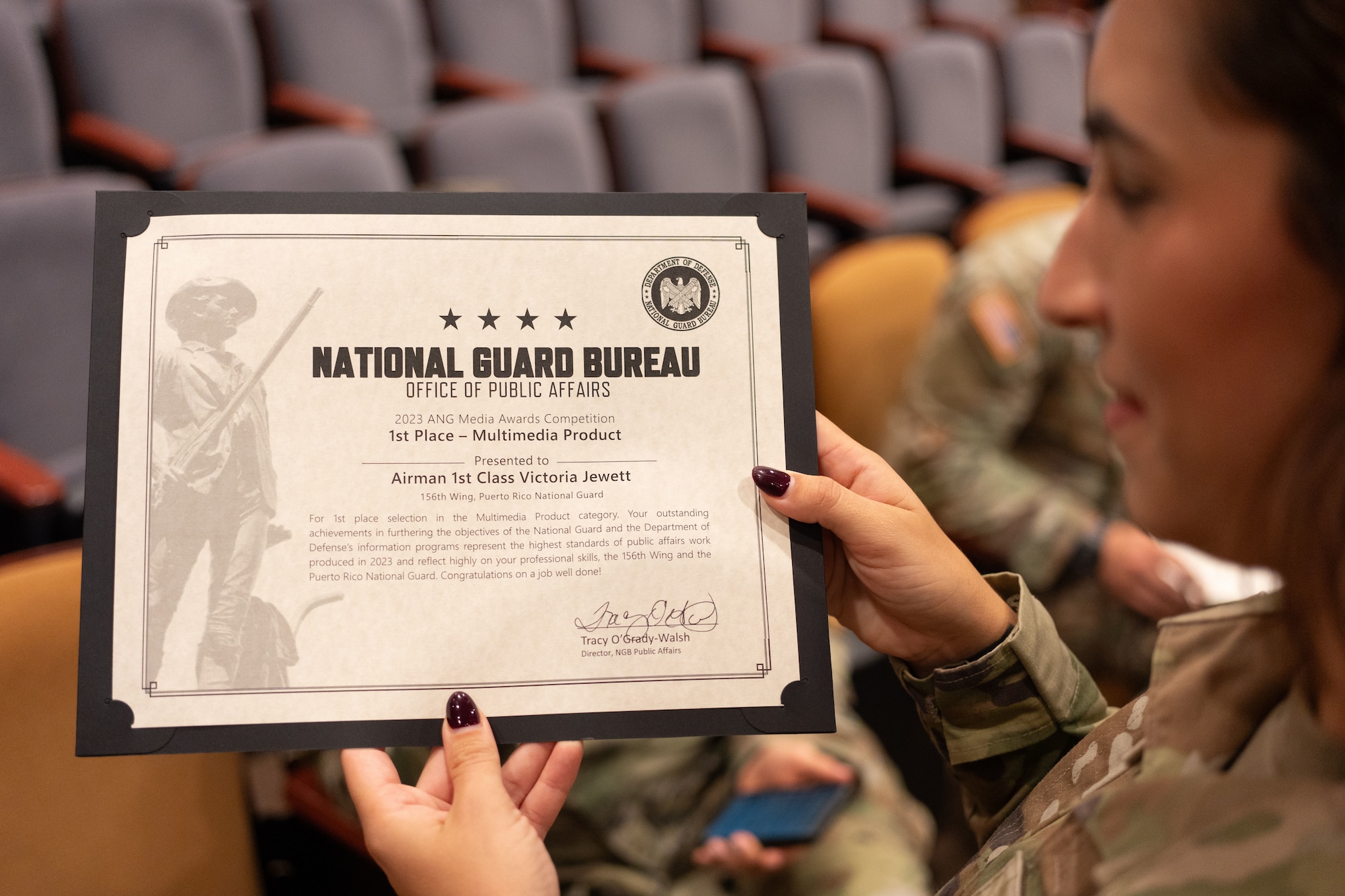 U.S. Air Force Airman 1st Class Victoria Jewett, a public affairs specialist with the 156th Wing, Puerto Rico Air National Guard, receives a first-place certificate in the Multimedia Product category of the Air National Guard Media Awards Competition from Tracey O' Grady-Walsh, director of Public Affairs for the National Guard Bureau, during the National Guard's annual Public Affairs Training Workshop Conference at the Mark Center, Alexandria, Virginia, July 11, 2024. The PATW is a three-day training event that is attended primarily by speakers and public affairs professionals providing expansive talks from strategic leaders and collaborative networking to bridge the PA community across the 54 U.S. states and territories. (U.S. Air National Guard photo by Master Sgt. Rafael D. Rosa)