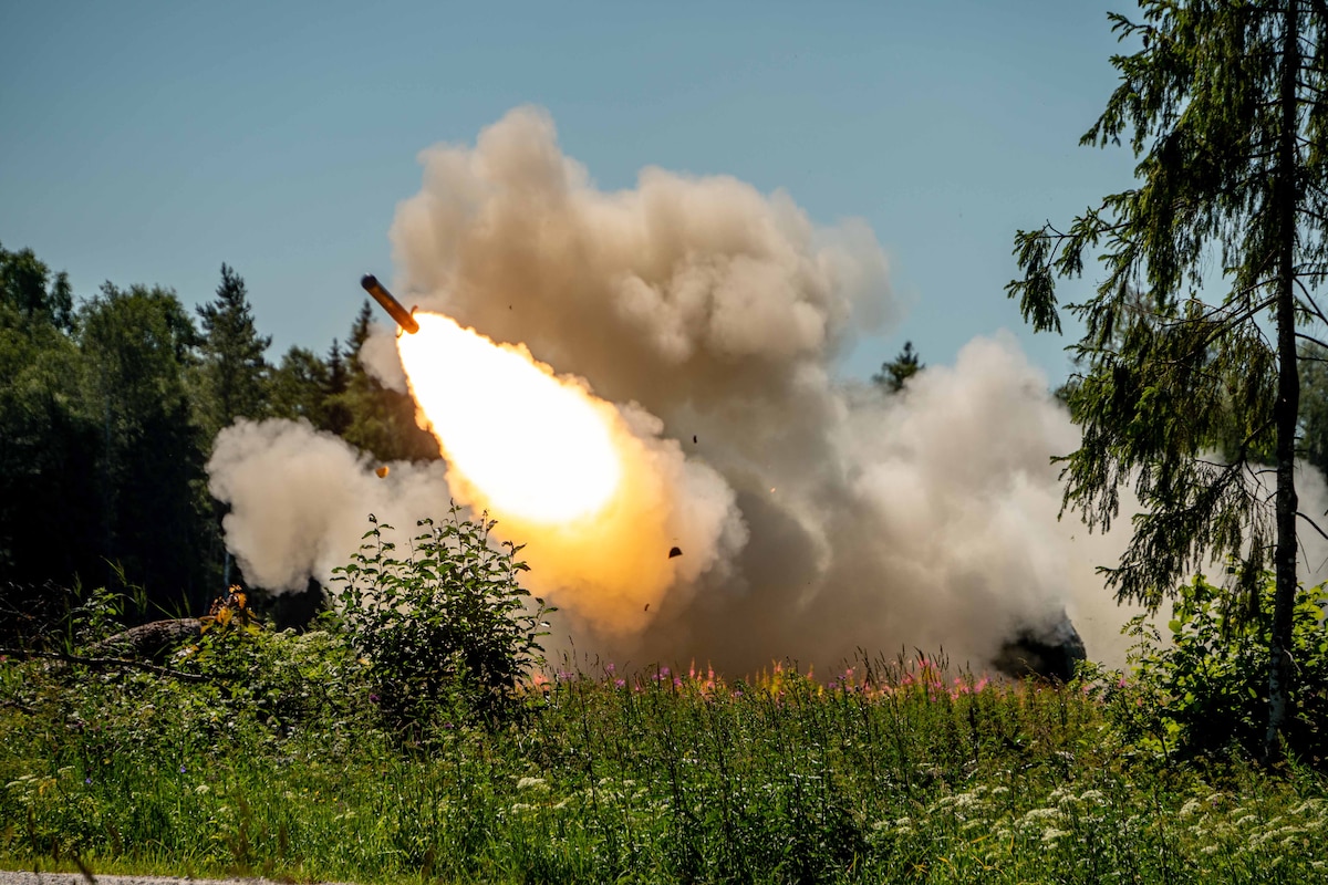 A rocket is launched sending flames and smoke into the air.