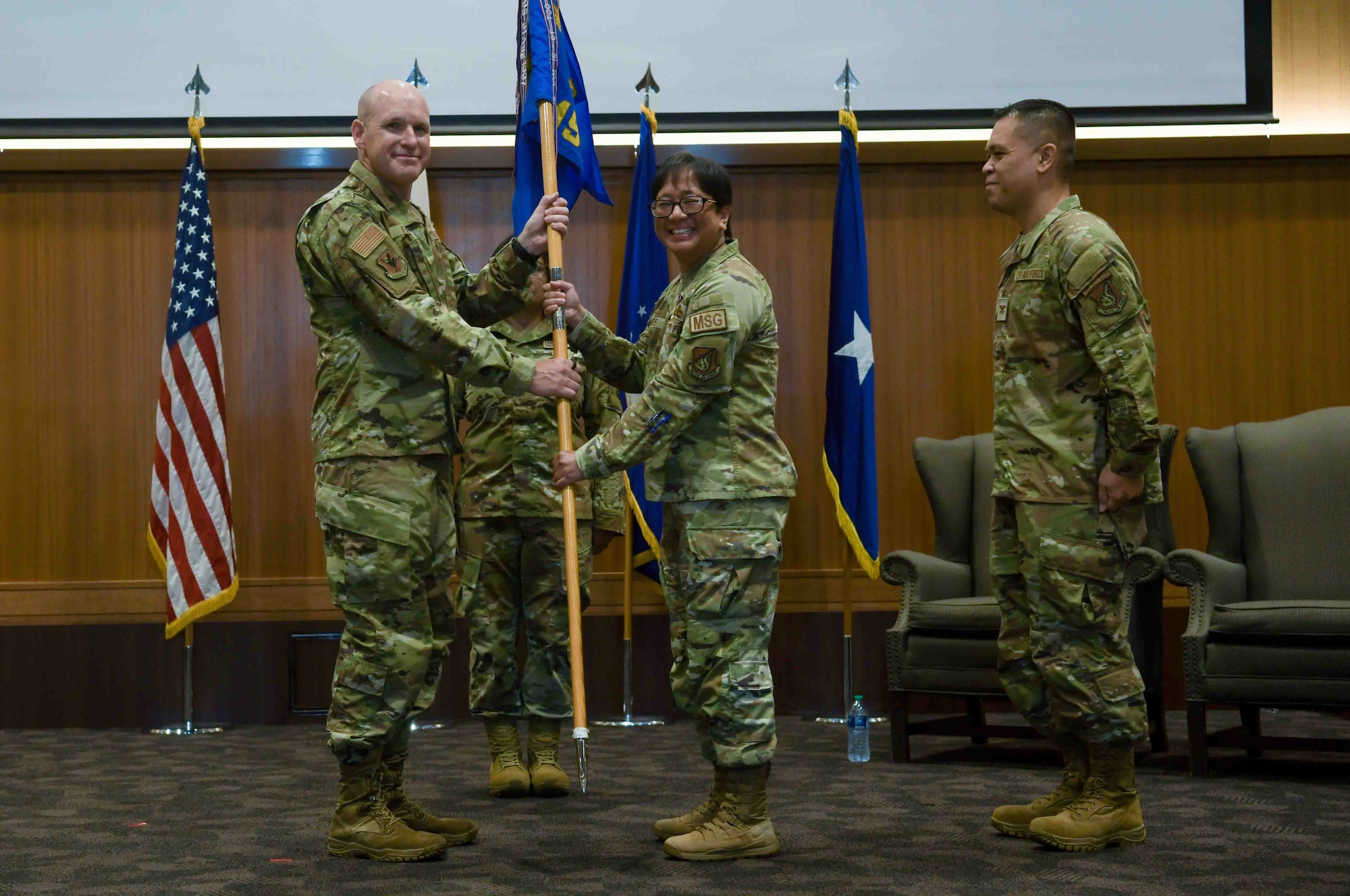 U.S. Air Force Col. Laura Ramos, center, outgoing 18th Mission Support Group commander, relinquishes the guidon to Brig. Gen. Nicholas Evans, left, 18th Wing commander, during the 18th MSG change of command ceremony at Kadena Air Base, Japan, July, 18, 2024.