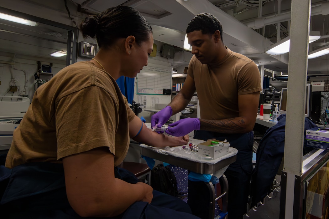 240709-N-NA571-2020 SAN DIEGO (July 9, 2024) Hospital Corpsman 3rd Class Casey Young, right, from Mount Olive, N.C., draws blood from Lt. Charlene Wright, from San Diego, during a walking blood bank aboard the Nimitz-class aircraft carrier USS Abraham Lincoln (CVN 72). Abraham Lincoln is currently moored pierside at Naval Air Station North Island. (U.S. Navy photo by Mass Communication Specialist 3rd Class Valerie Morrison)