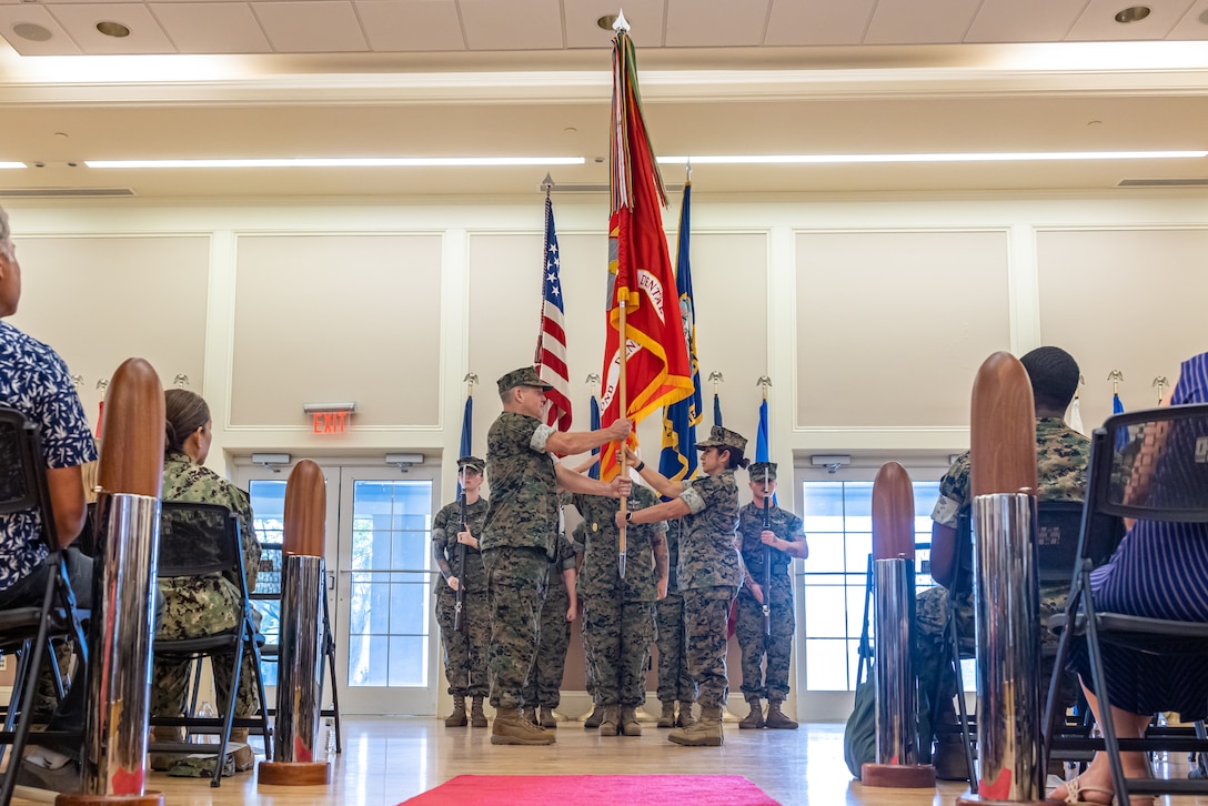 U.S. Navy Capt. Eric Evans, left, incoming commanding officer, 2nd Dental Battalion, 2nd Marine Logistics Group, receives Battalion colors from Capt. Sherry Caraveo, outgoing commanding officer, 2nd Dental Battalion, 2nd MLG, during a change of command ceremony on Camp Lejeune, North Carolina, July 12, 2024.  During the ceremony, U.S. Navy Capt. Sherry Caraveo relinquished command of 2nd Dental Battalion to Capt. Eric Evans. (U.S. Marine Corps photos by Lance Cpl. Christian Salazar)