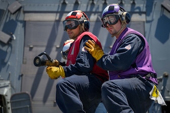 GSM1 Brandon Gauthier, right, and DC2 Daniel Johnston train during an aviation firefighting drill aboard USS Gridley (DDG 101).