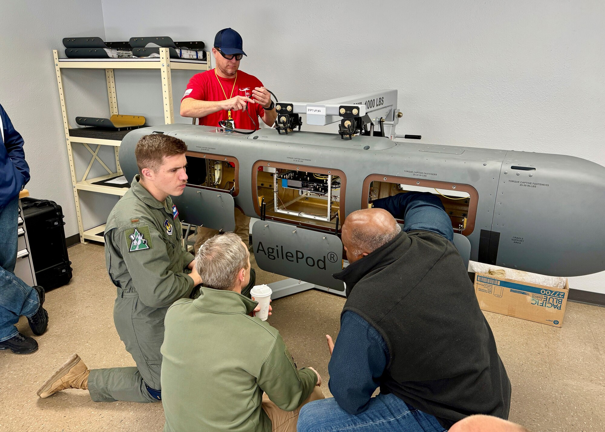 Allen Parker, NASA’s Armstrong Flight Research Center Fiber Optic Sensing System engineer, explains the AgilePod’s capabilities to Air Force Test Pilot School staff, while David Brown, 586th Flight Test Squadron, makes modifications to the pod. (Courtesy photo)