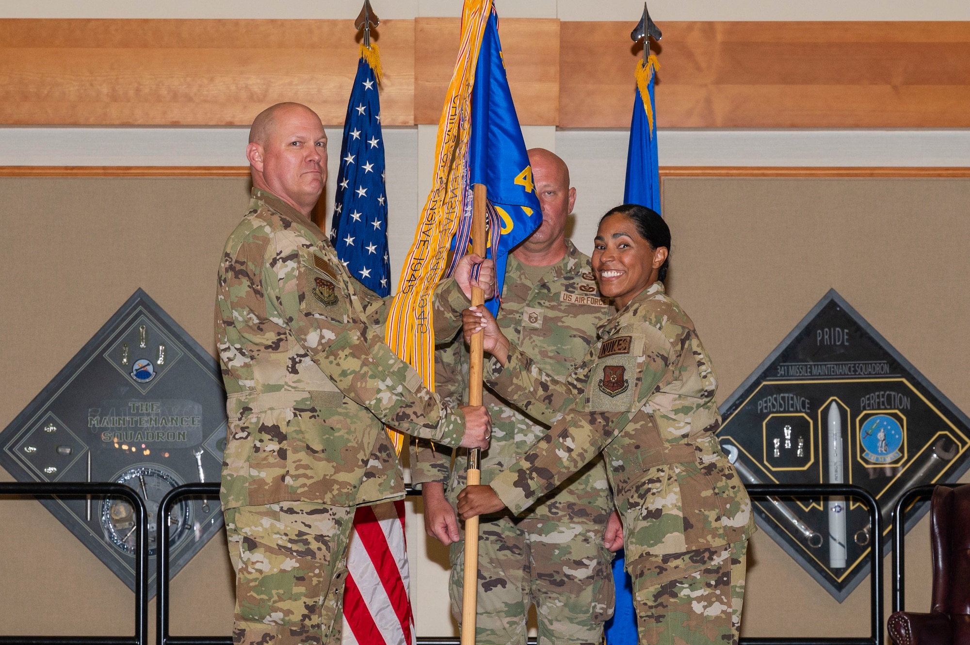 two people holding onto the pole of a flag.