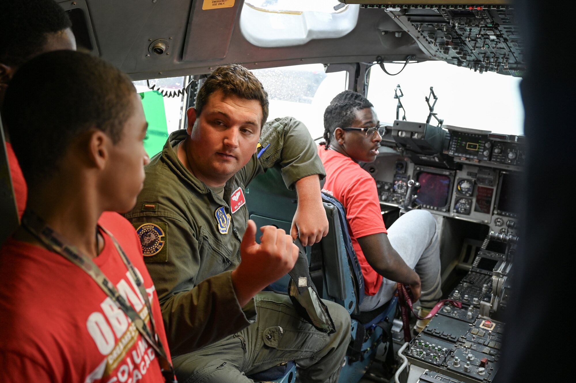 Second Lt. William Phillis III, 89th Airlift Squadron pilot, shows the cockpit of a C-17 Globemaster III to young members of Buckeye Tigers during a tour of the 445th Airlift Wing at Wright-Patterson Air Force Base, Ohio, July 10, 2024. The Buckeye Tigers Aviation Program is an aviation organization focused on exposing young adults in middle and high school to various aviation careers in the Columbus and greater Central Ohio region.  Members get to experience actual flight in a real single engine airplane as the culminating event of OBAP’s (Organization of Black Aerospace Professionals) sponsored A.C.E. (Aviation Career Education) Academy. (U.S. Air Force photo by Mr. Patrick OReilly)
