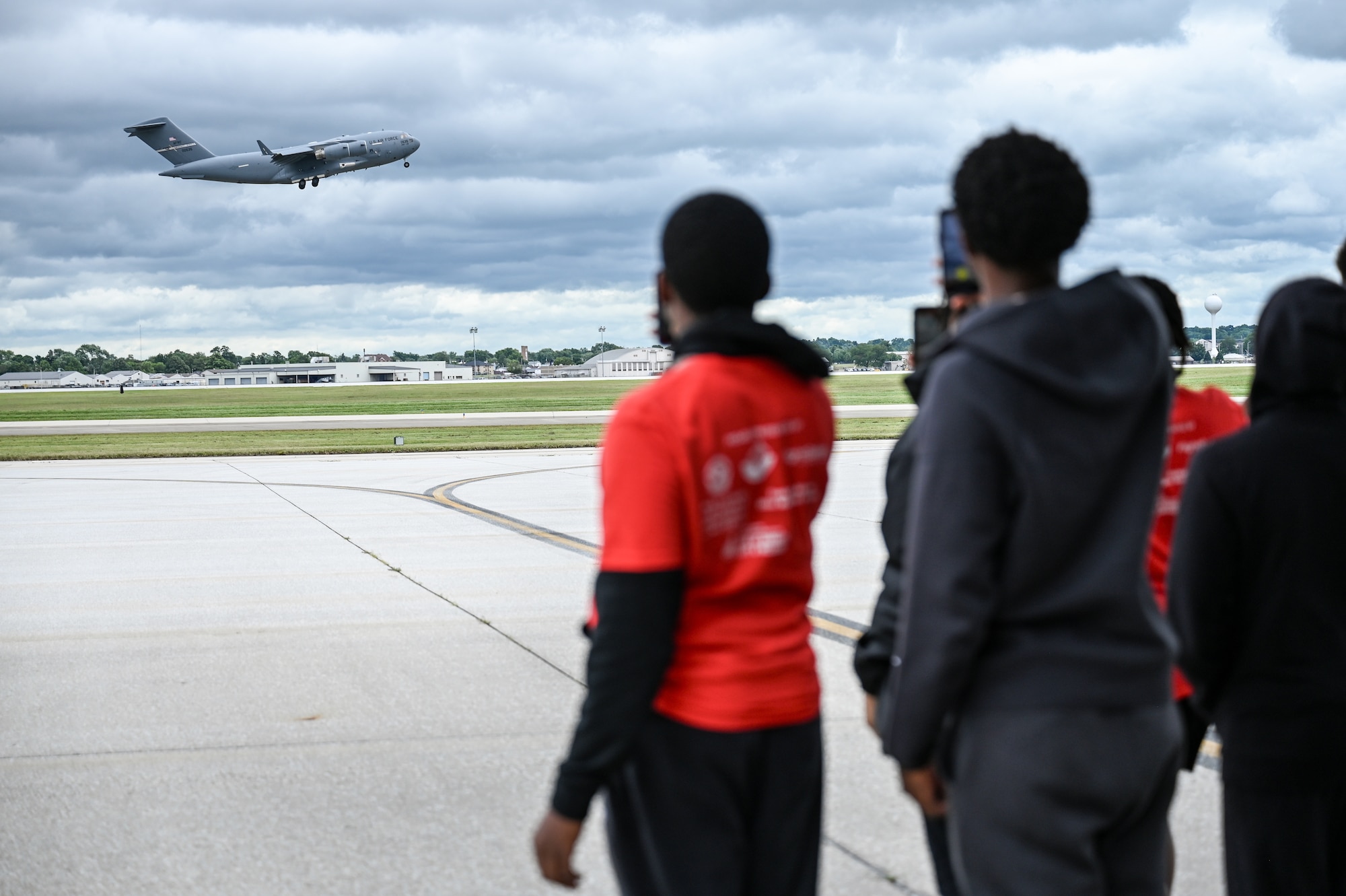 Members of Buckeye Tigers watch a 445th Airlift Wing C-17 Globemaster III perform touch and goes on the flightline at Wright-Patterson Air Force Base, Ohio July 10, 2024. During their visit to the wing, the group toured a 445th AW C-17 Globemaster III, received a briefing by an Air Force recruiter about career fields offered in the Air Force and what it’s like to serve in the military. The group also with Col. Michael Baker, 445th Operations Group commander, who spoke about and answered their questions about serving in the Air Force Reserve. The Buckeye Tigers Aviation Program is an aviation organization focused on exposing young adults in middle and high school to various aviation careers in the Columbus and greater Central Ohio region.  Members get to experience actual flight in a real single engine airplane as the culminating event of OBAP’s (Organization of Black Aerospace Professionals) sponsored A.C.E. (Aviation Career Education) Academy. (U.S. Air Force photo by Mr. Patrick OReilly)